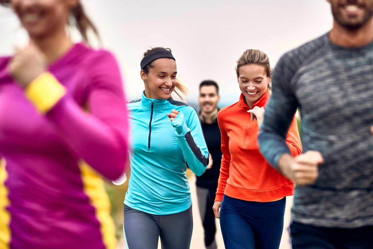 Happy Athletic Women Having Fun While Jogging With Group Of Peop